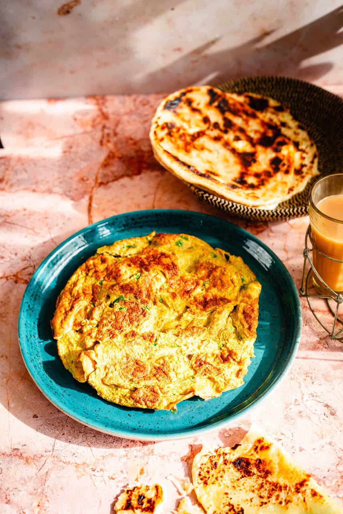 Indian Omelette with tea and paratha on table