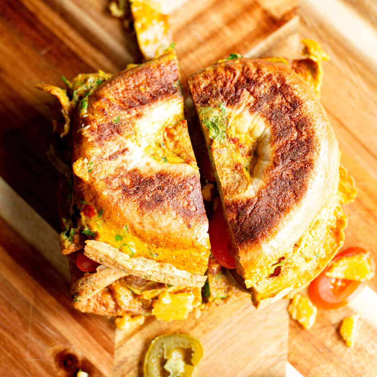 Delicious Indian Masala Omelette Masala omelette bagel on wooden board