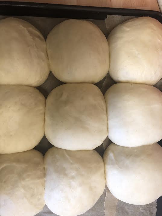 Milk buns doubled in size on lined tray