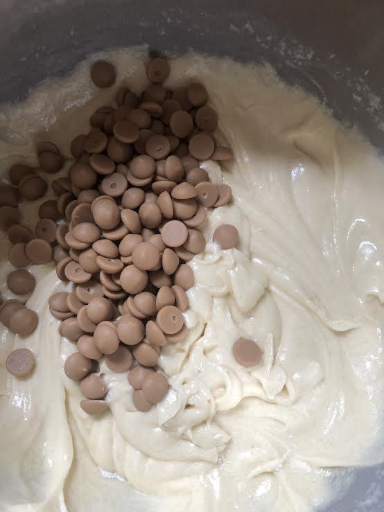 Blond chocolate added to cake batter in bowl