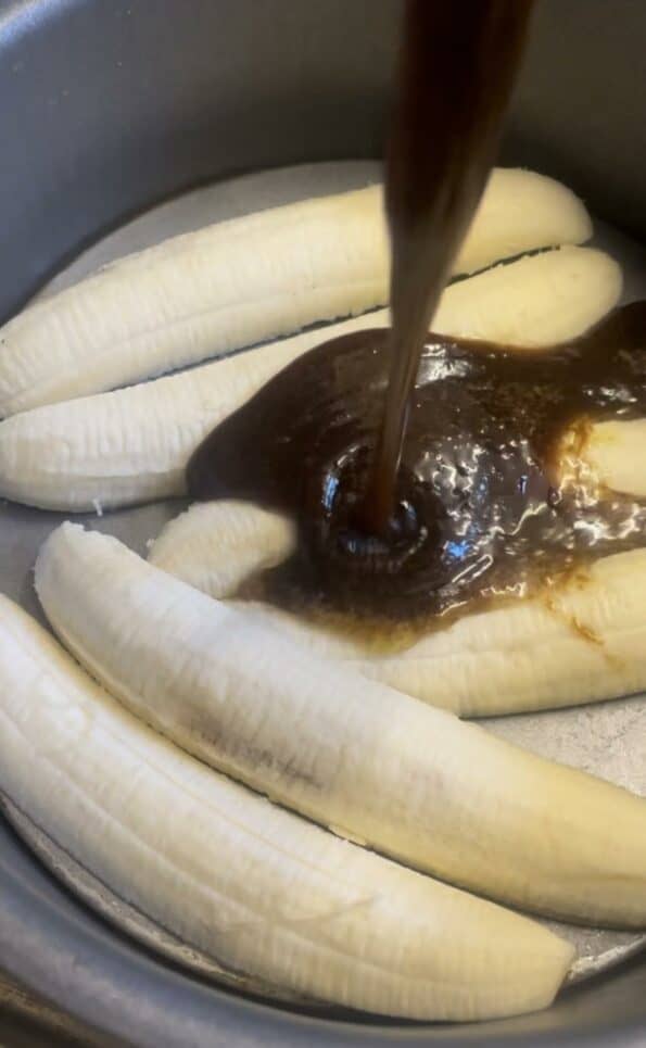 Caramel being poured on top of Bananas in tin