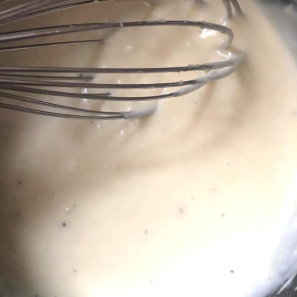 White sauce and whisk in pot