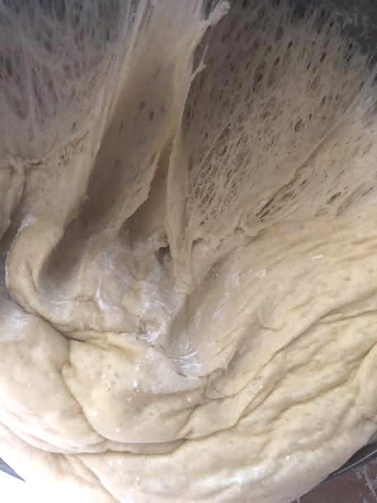 Stretched dough in bowl showing air bubbles