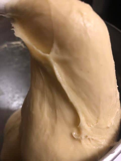 Shiny dough on dough hook in stand mixer