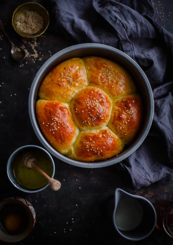 Chicken milk buns in flower shape in round tin with butter to side