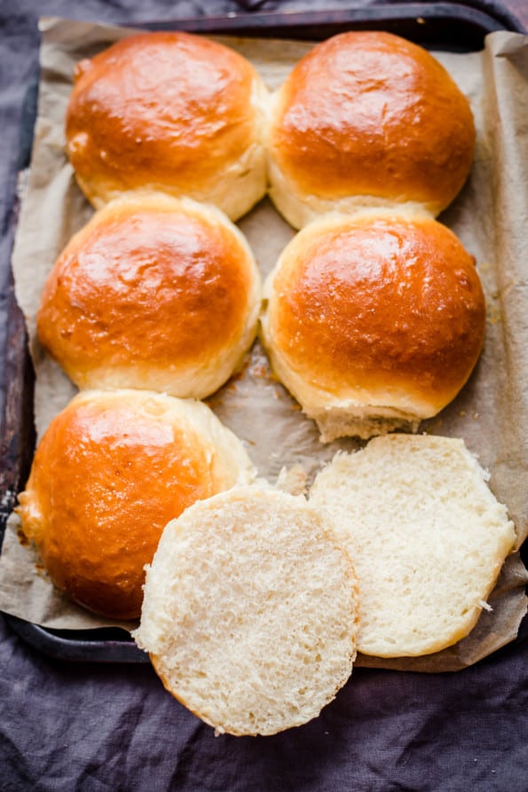 Buns on a tray with 1 sliced to show inside