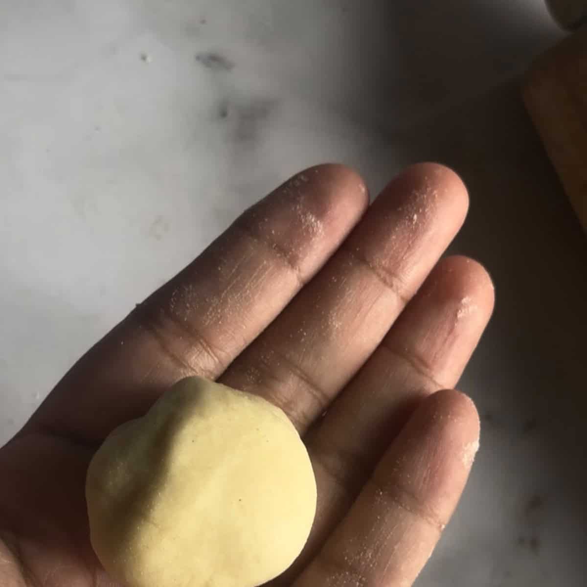 Bun in hand showing smooth bun with enclosed cheese
