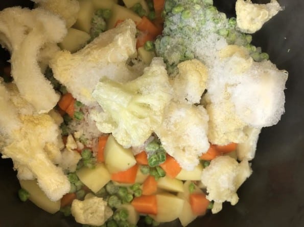 Frozen cauliflower and peas added to pot