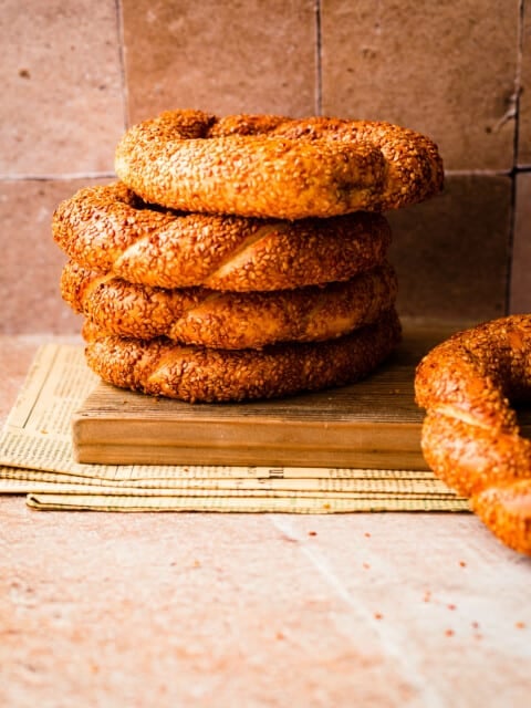 Simit in a pile against a tiled wall