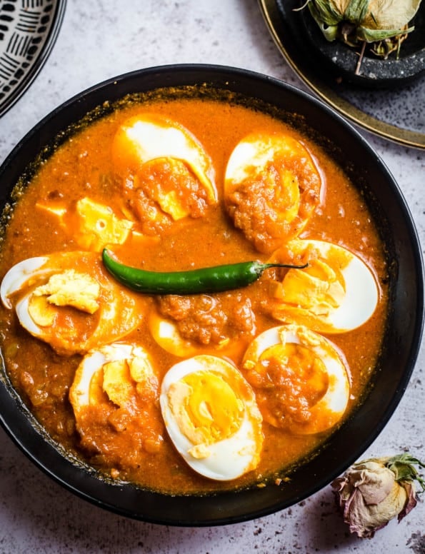Egg Curry in bowl with plates to side