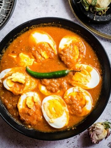 Egg Curry in bowl with plates to side