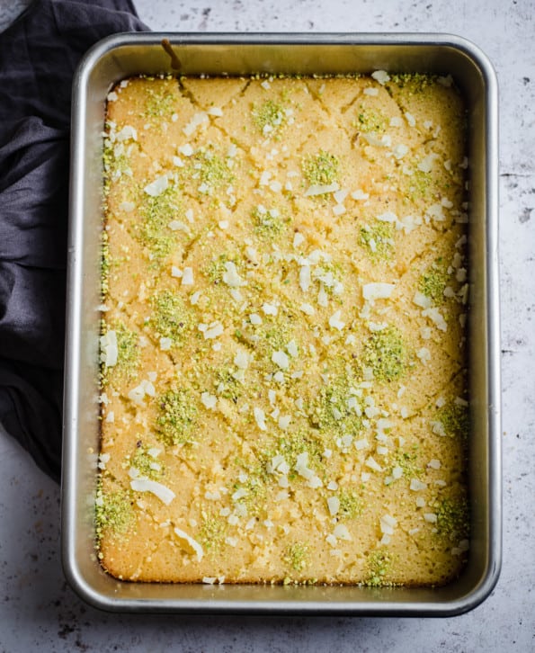 Revani in tray with pistachio and coconut topping