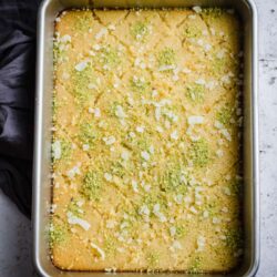 Revani in tray with pistachio and coconut topping