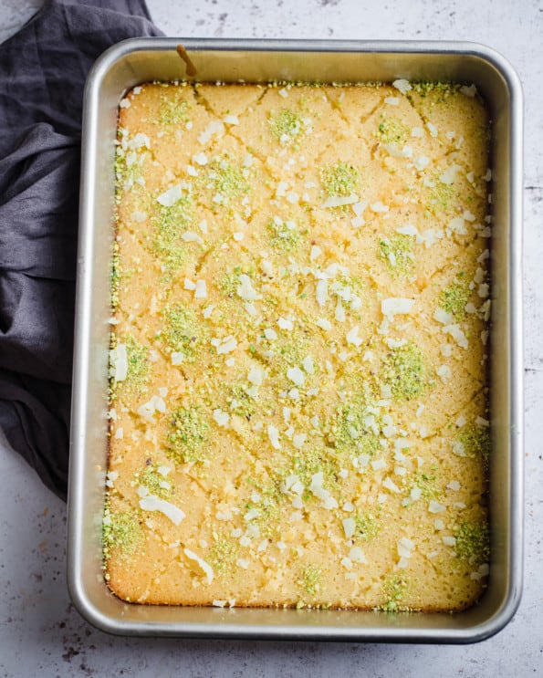 Revani topped with pistachio and cut in diamond shapes in tray