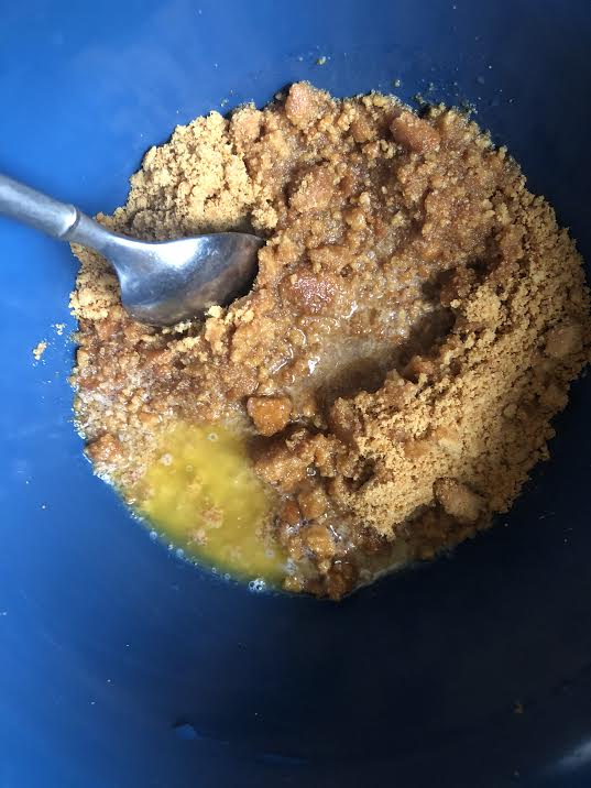 Melted butter, syrup and based biscuits in bowl with spoon