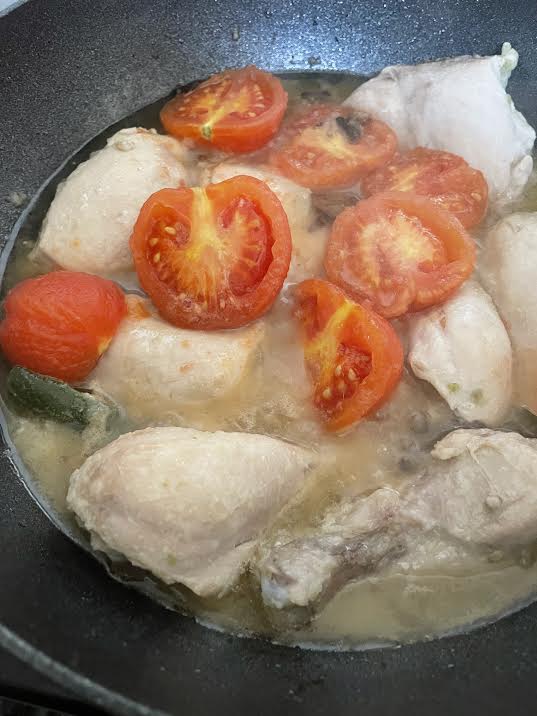 Tomatoes cooking on top of Chicken 