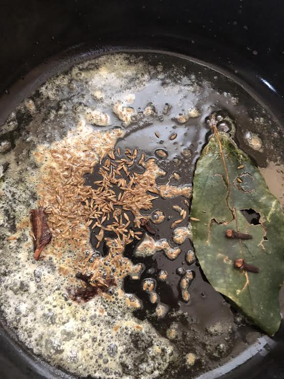 Cumin, Bay leaves and spices in pot with ghee