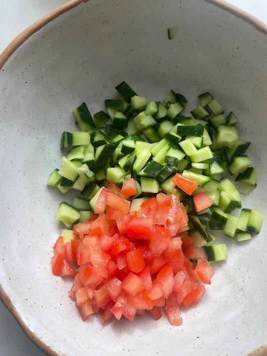 Tomatoes added to bowl with cucumber