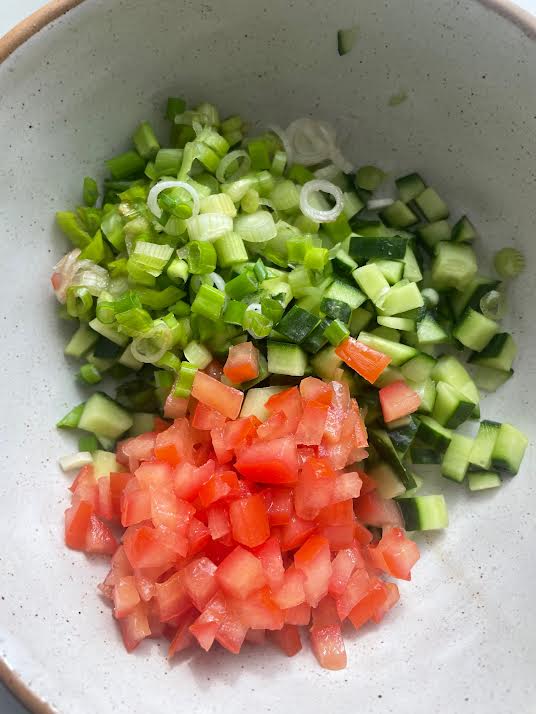 Spring onions added to salad bowl