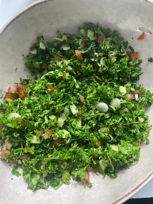 Parsley added to salad bowl