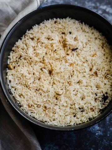 Jeera Rice in Black pot with towel to side