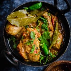 Karahi Chicken in wok with spices in plate to side