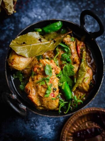 Karahi Chicken in wok with spices in plate to side
