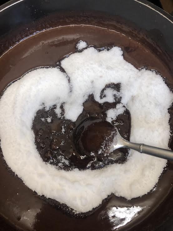 Sugar being stirred into pan