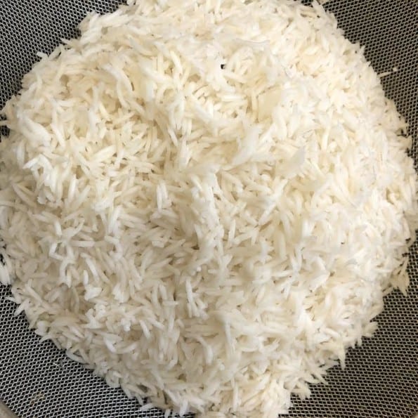 Par boiled rice straining in mesh strainer