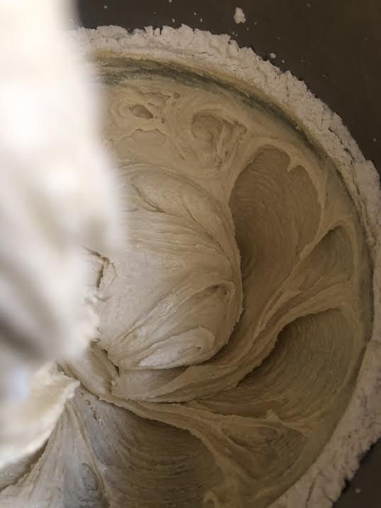 Flour being golden into batter in bowl