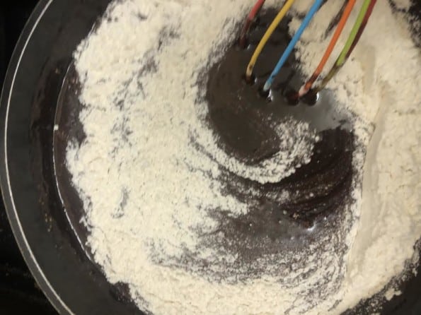Flour being whisked into pan