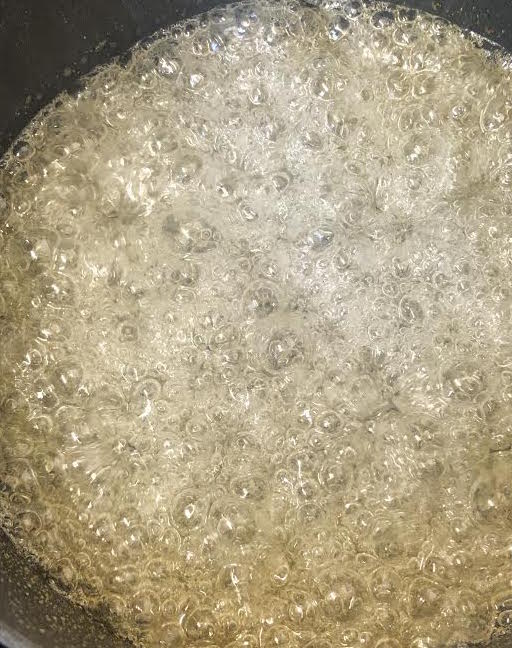 Sugar and water bubbling in pan