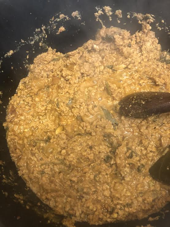 Cooked mince in pot with wooden spoon