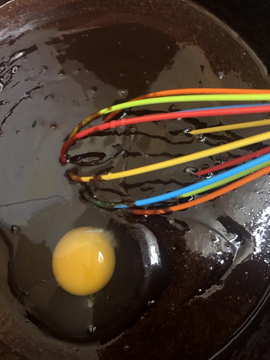 Egg being whisked into pan 