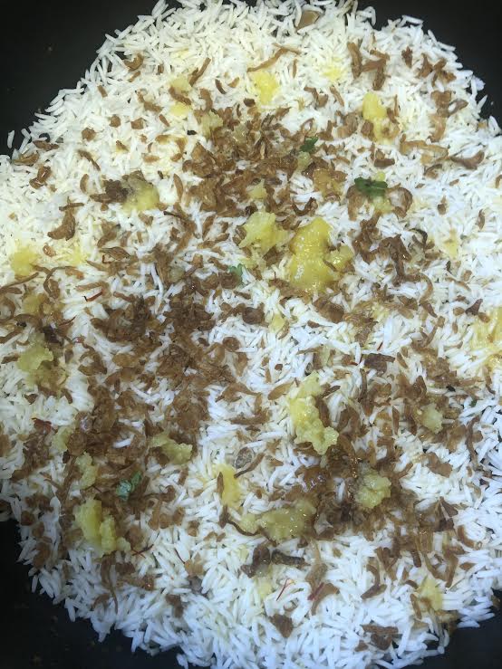 Final rice layer with ghee and onions on top