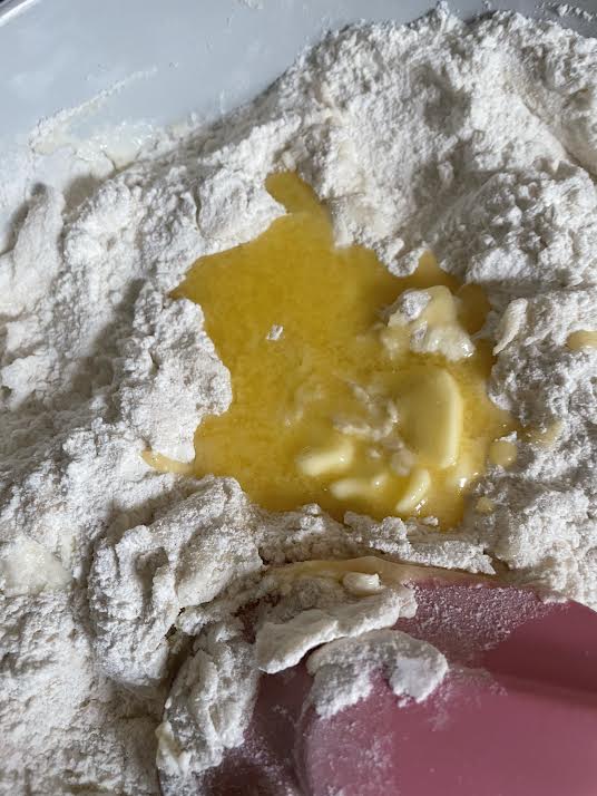 Melted butter being poured into flour