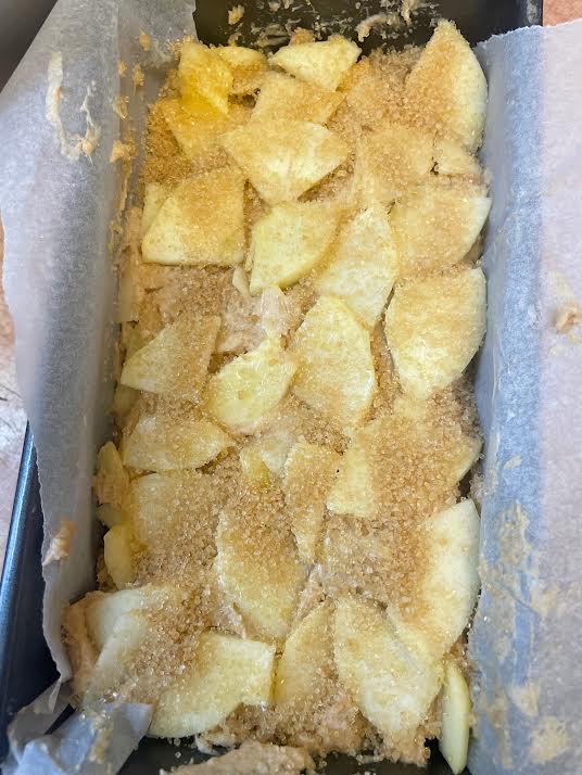 Apples added to top of cake in loaf pan