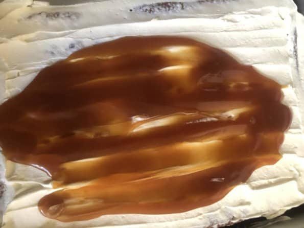 Caramel being spread over cake
