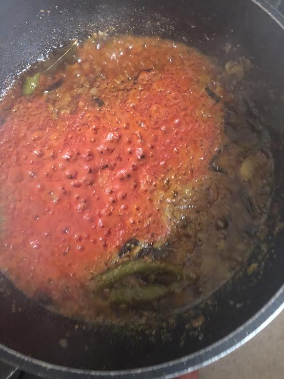 Tomato cooking out in pot with onion base
