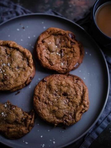 4 chai cookies in plate with cup of tea to side
