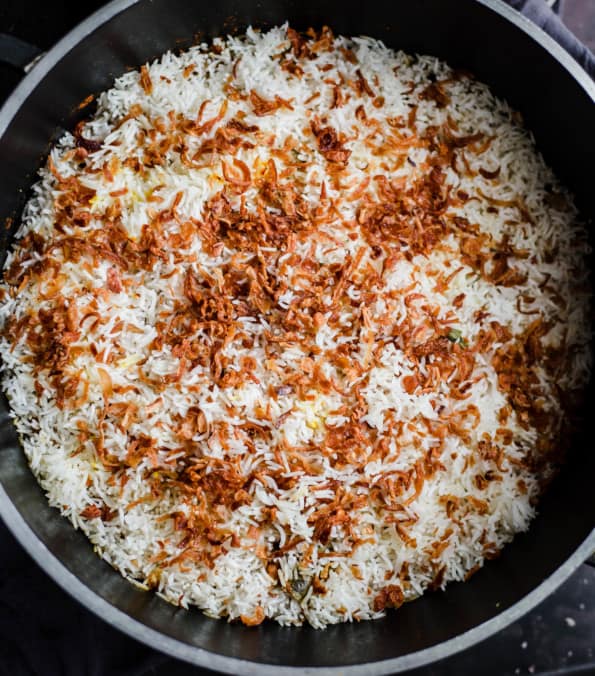 Onions added to top of rice in pot