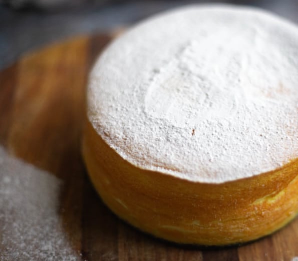 Smaller Cotton Cheesecake on a board with a generous dusting of of icing sugar