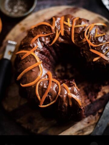 Chocolate Orange Cake on a wooden board with orange peel on top