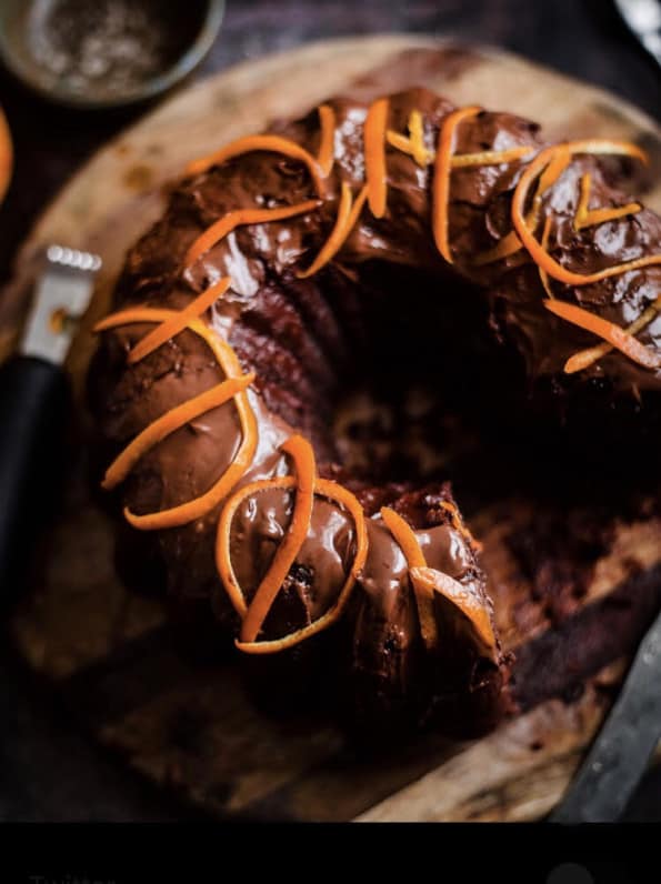 Chocolate Orange Cake on a wooden board with orange peel on top