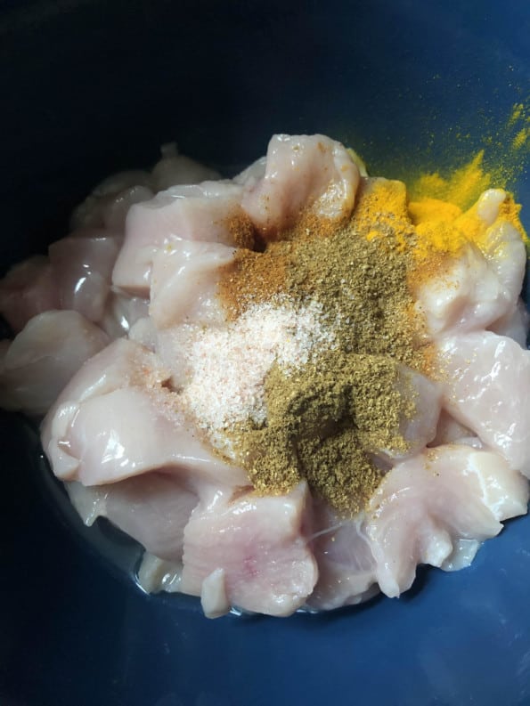 Chicken being marinaded in bowl