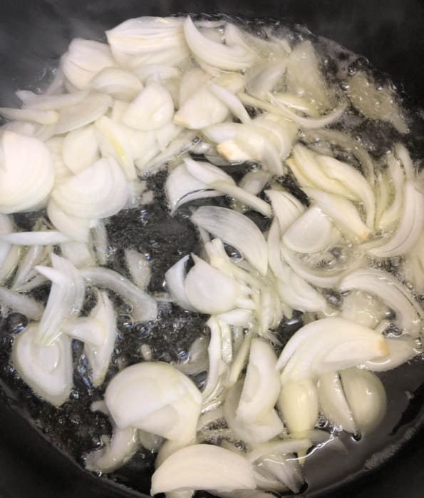 Sliced Onions added to oil in deep pan