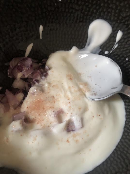 Plain yoghurt, red onion and salt in bowl