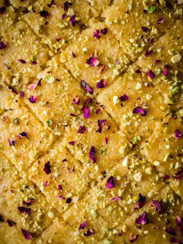 Baklava traybake cut into diamond shapes with pistachio and rose petals scattered on top