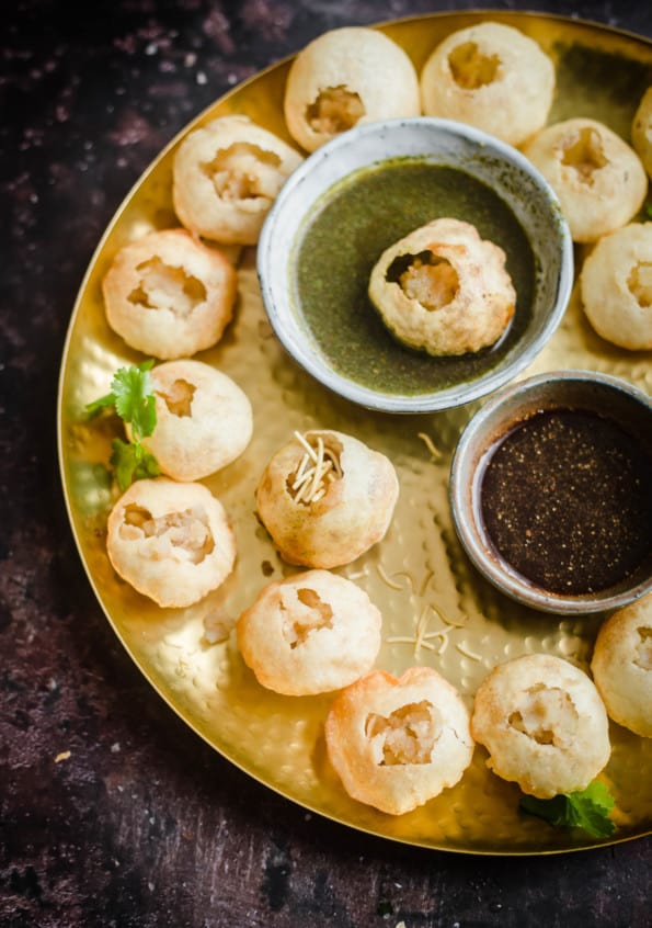 Puris on a platter with chutneys in the middle