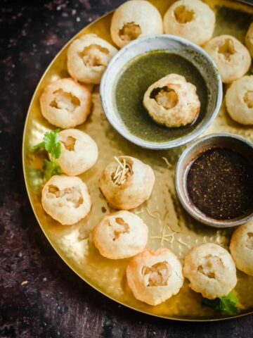 Puris on a platter with chutneys in the middle